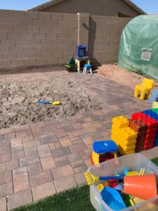 Sandbox with artificial grass and pavers